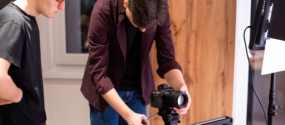 Photo session at home. Two photograpger, one is holding camera on the horizontal bar